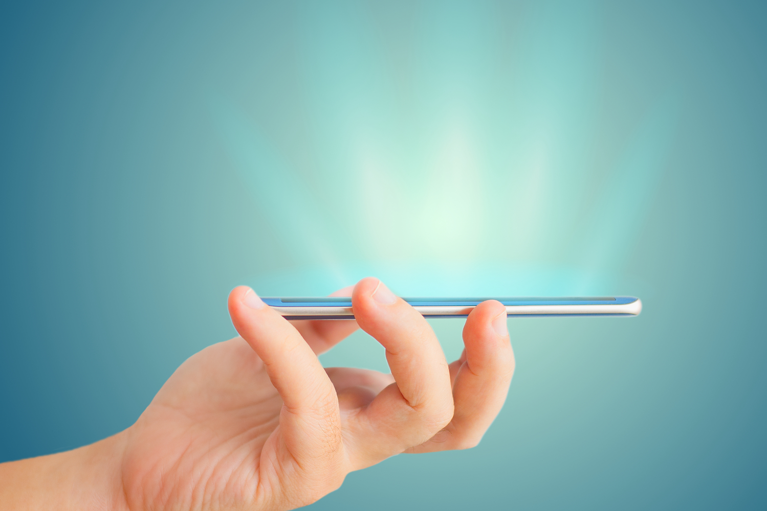 Human hand holding a smart phone horizontally against a blue background
