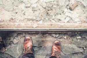 leather boots standing on the edge of a pile of shattered glass